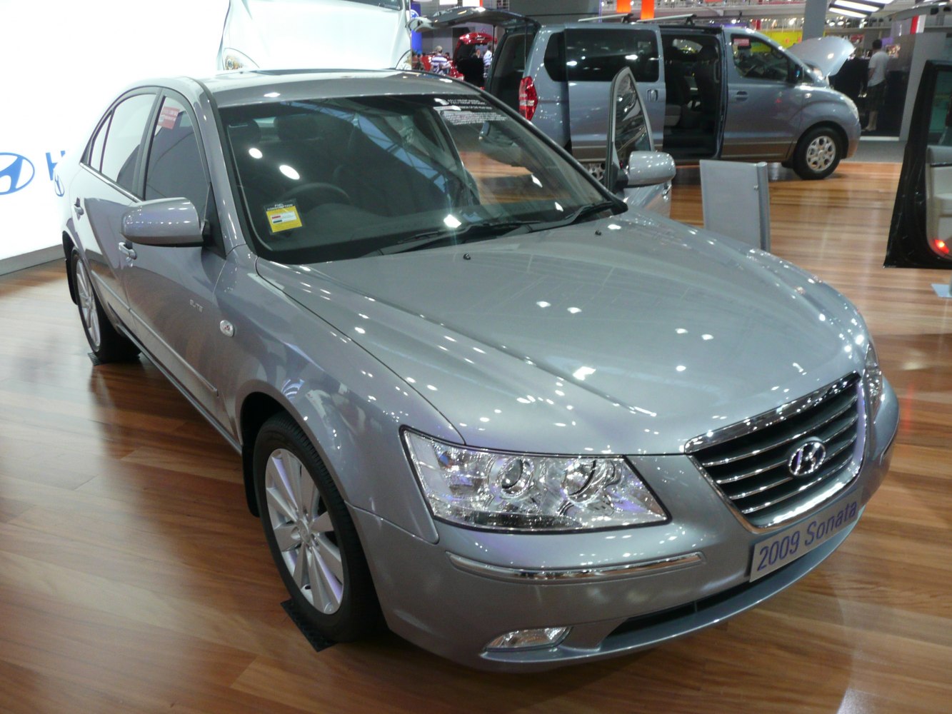 Front angled view of silver mid-size sedan with chrome grille and clear headlights