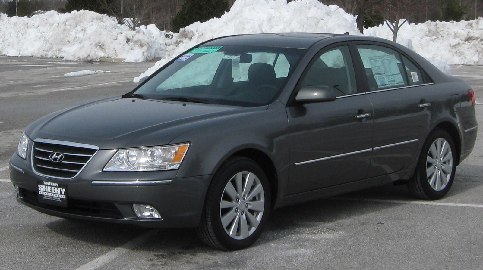 Front side view of sedan with alloy wheels in winter parking lot
