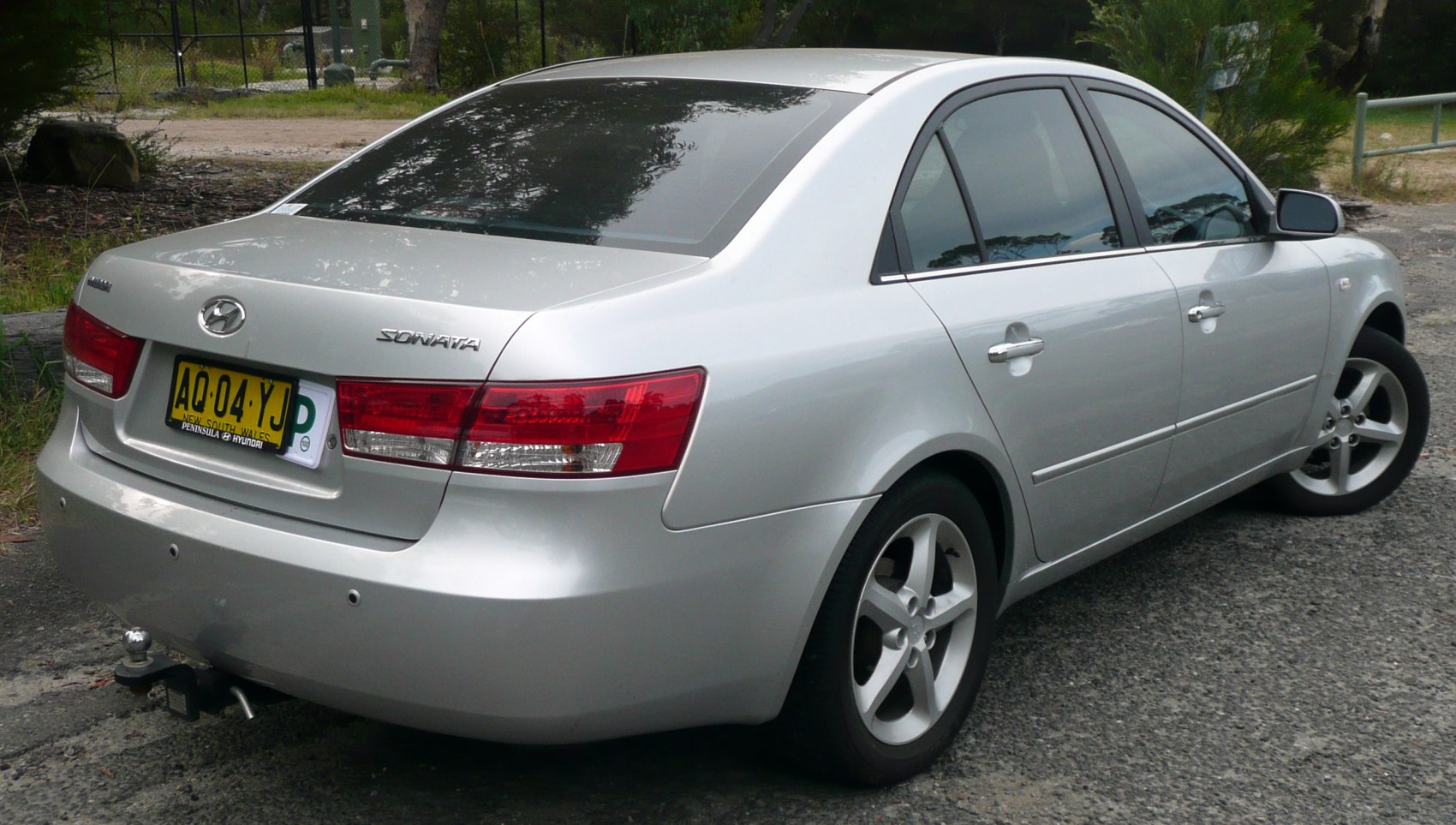 Silver sedan rear and side view with distinctive taillights and alloy wheels