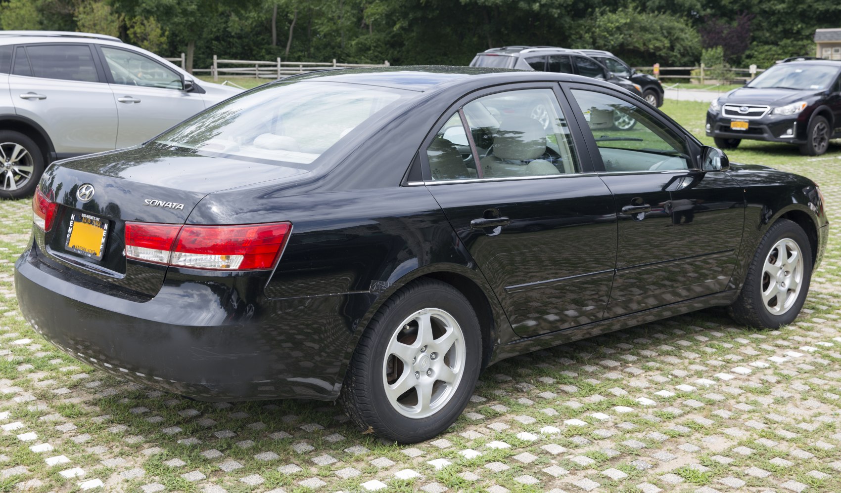 Rear and side view of a black sedan with distinctive taillights and smooth body lines