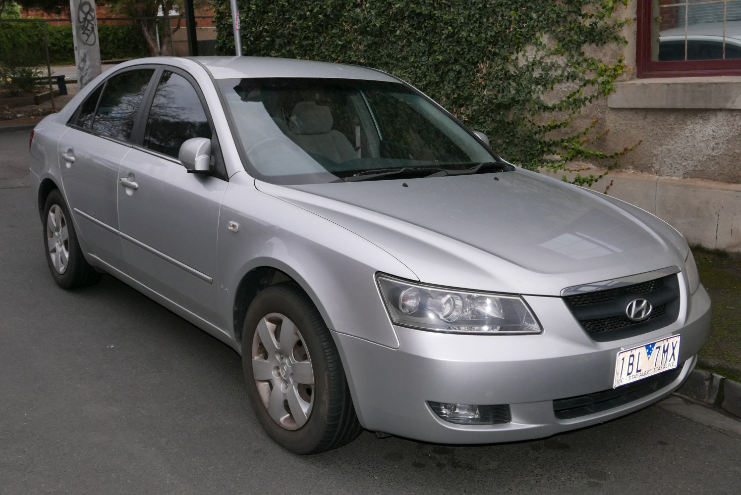 Silver four-door sedan with prominent headlights and grille