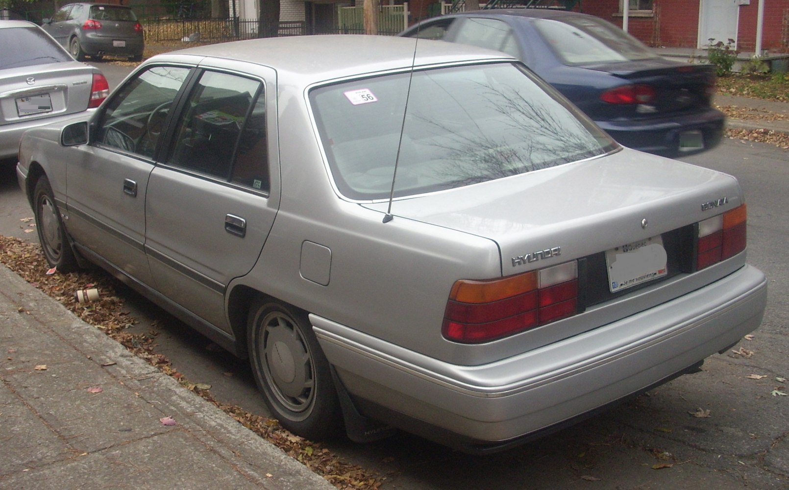 Rear view of classic late 80s four-door sedan with antenna and rectangular taillights