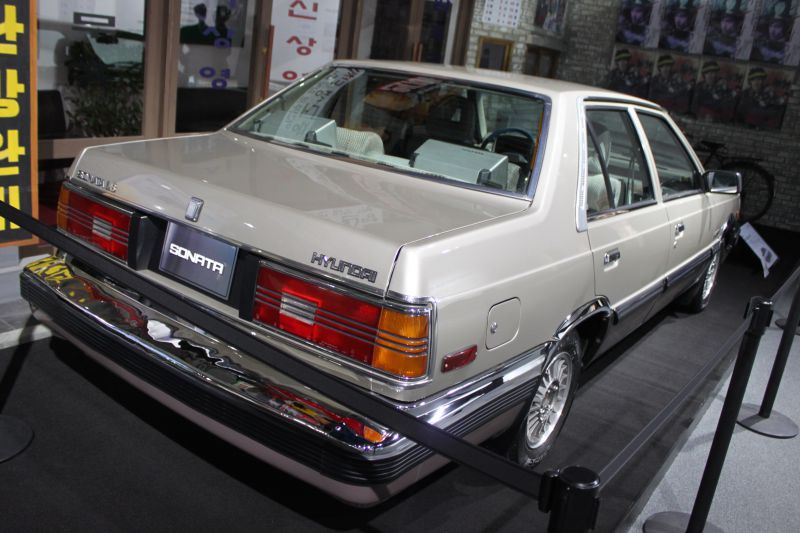 Rear view of classic sedan with distinctive tail lights and chrome bumper.