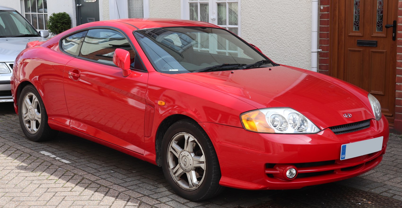 Red two-door coupe with sleek sporty design, front side view
