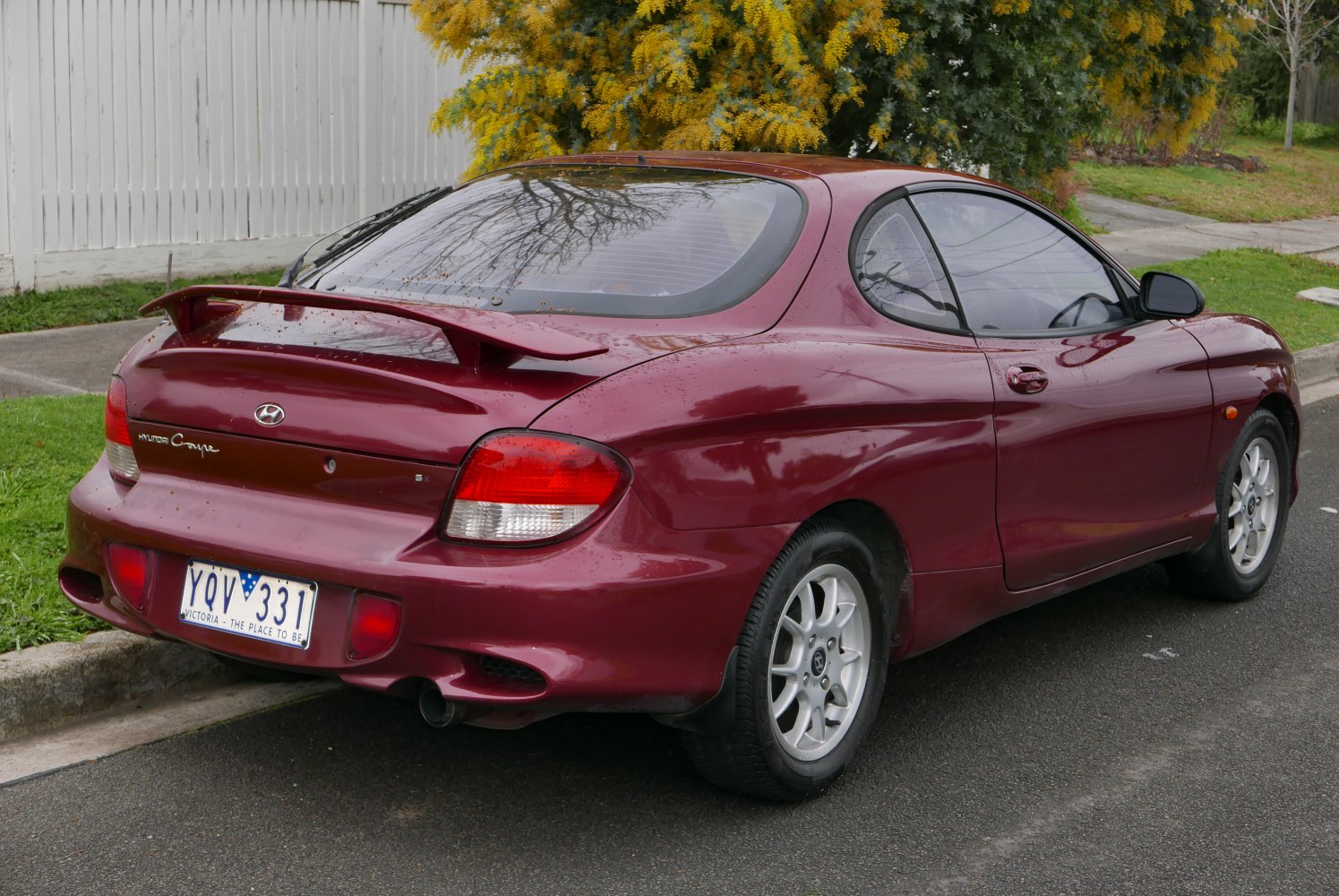 Rear-side view with rear spoiler and alloy wheels