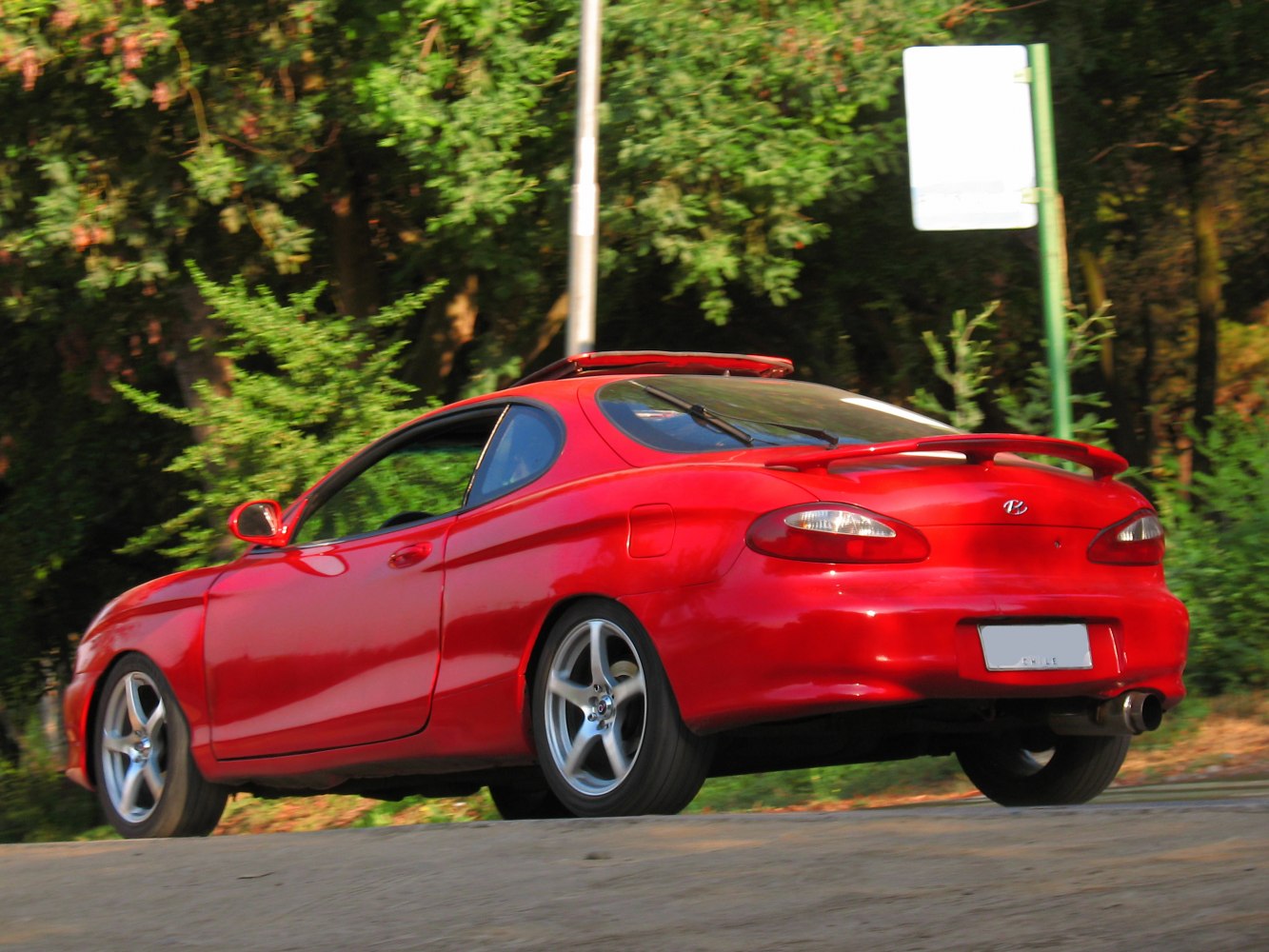 Rear view of red coupe with spoiler and alloy wheels