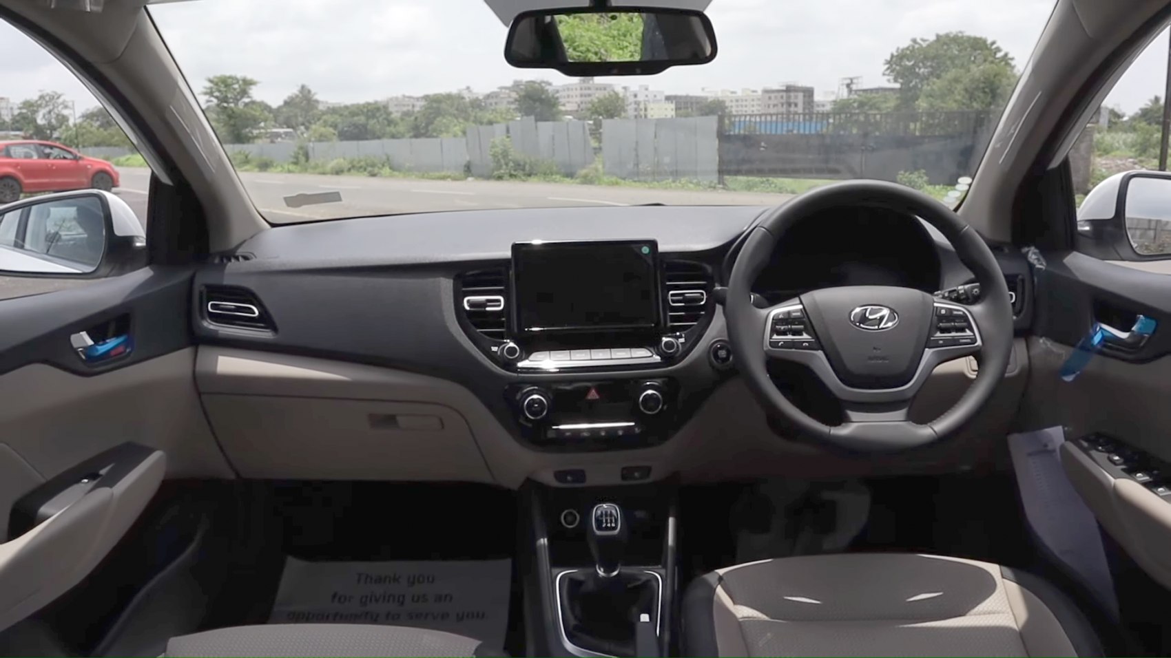 Car interior with dashboard, touchscreen, steering wheel, and manual gear shift
