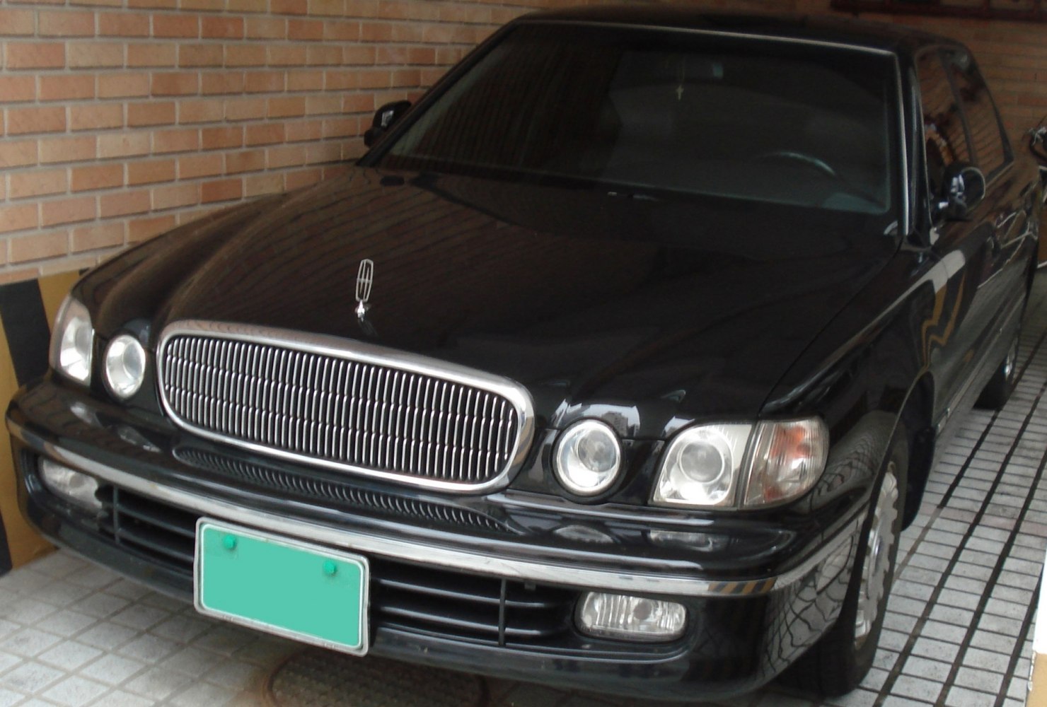 Classic chrome grille and dual round headlights in luxury sedan front view