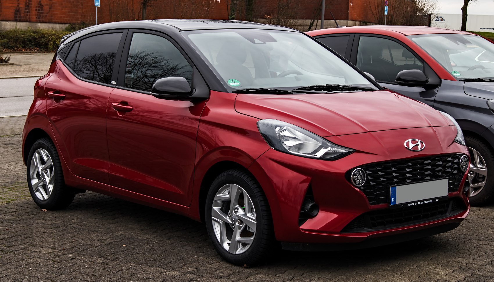 Red compact hatchback with LED fog lights and alloy wheels