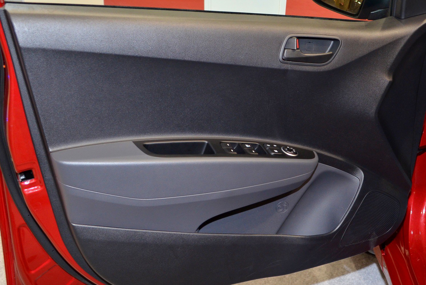 Interior door panel with handle, controls, and speaker