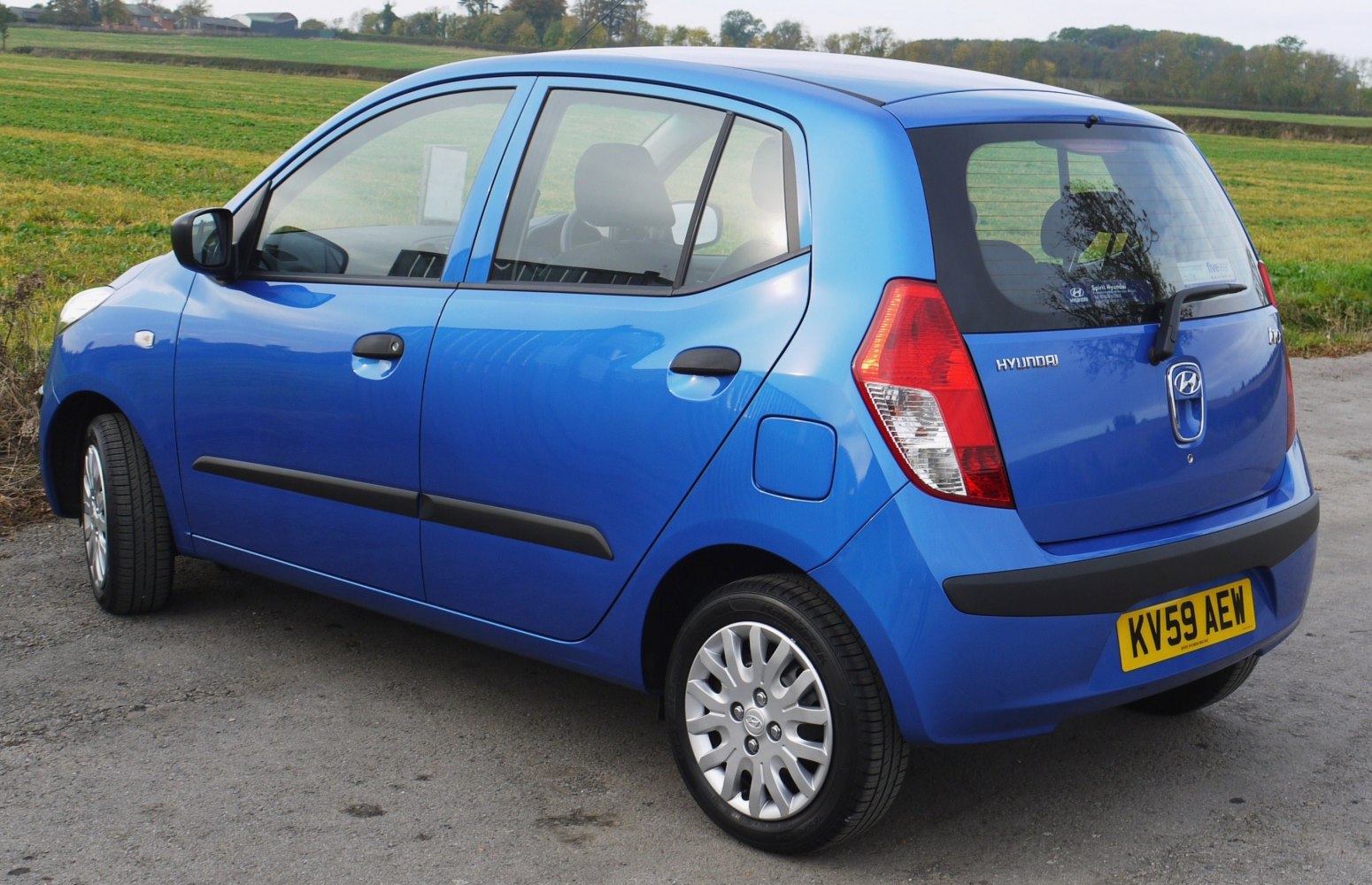 Rear side view of blue compact hatchback with distinct taillights and five-door design