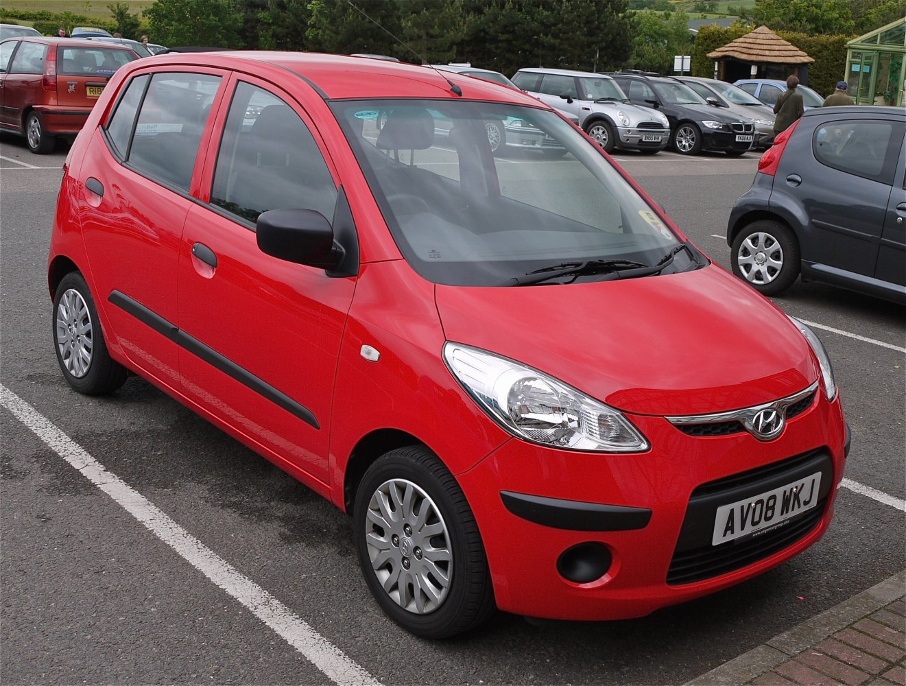 Red compact hatchback car front-side angle