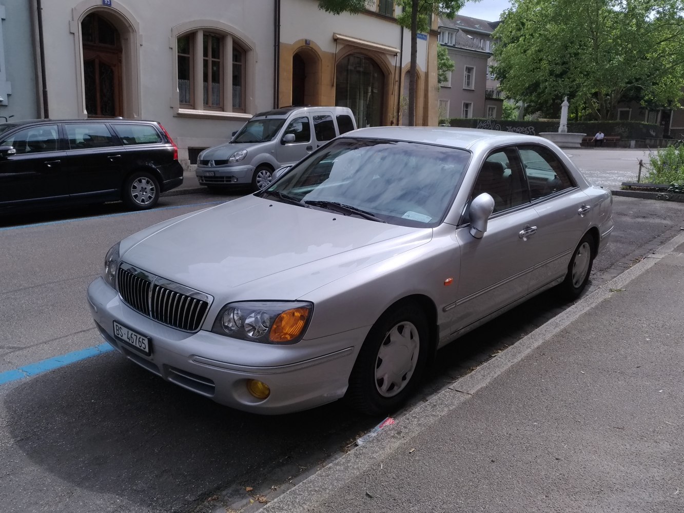 Silver sedan front view with distinctive grille and headlights