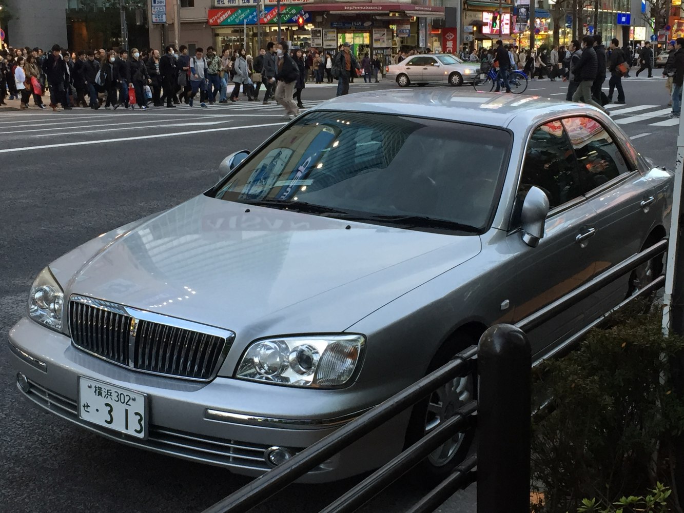 Silver luxury sedan with chrome grille and quad headlights