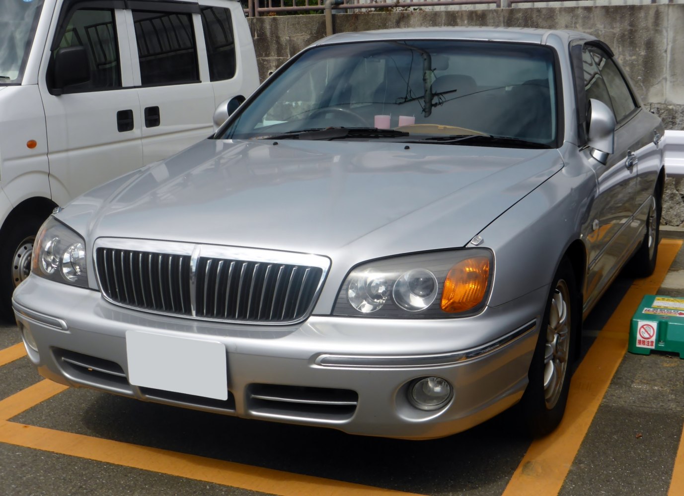 Vertical grille and dual headlights on silver sedan front