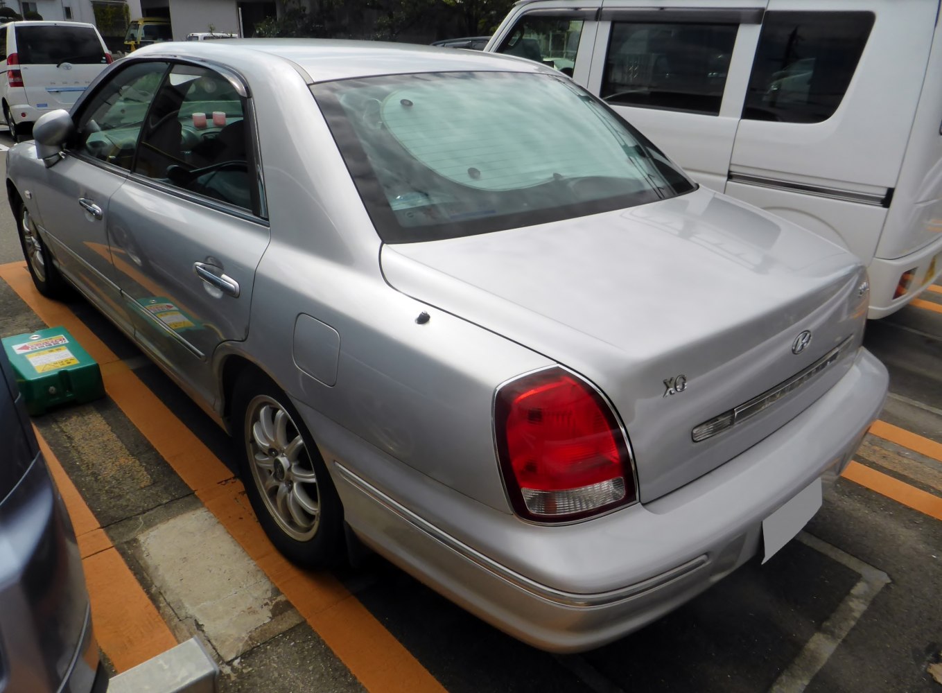 Silver sedan rear side view with taillights and chrome trim