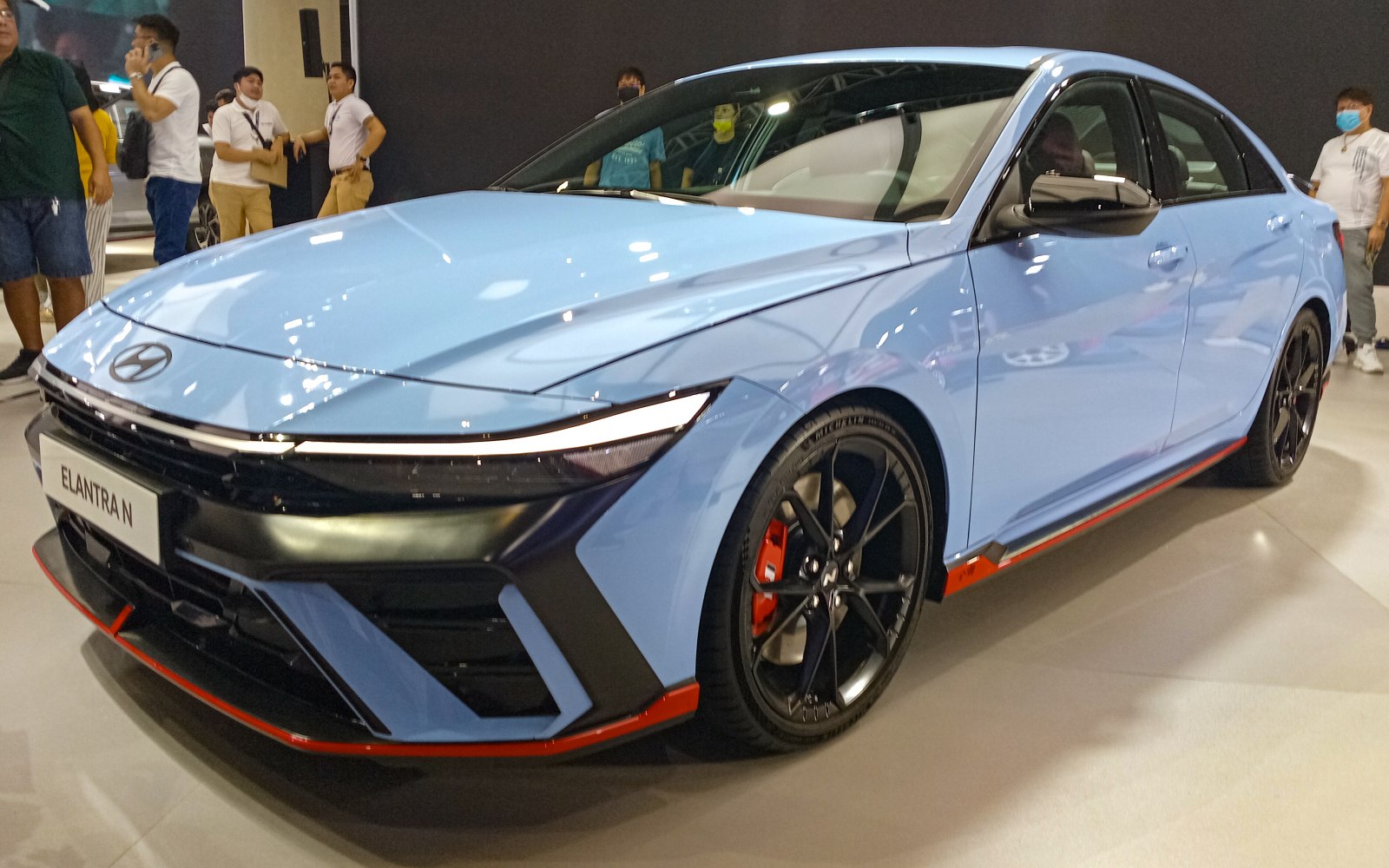 Modern light blue sedan with LED headlights and sporty black wheels.
