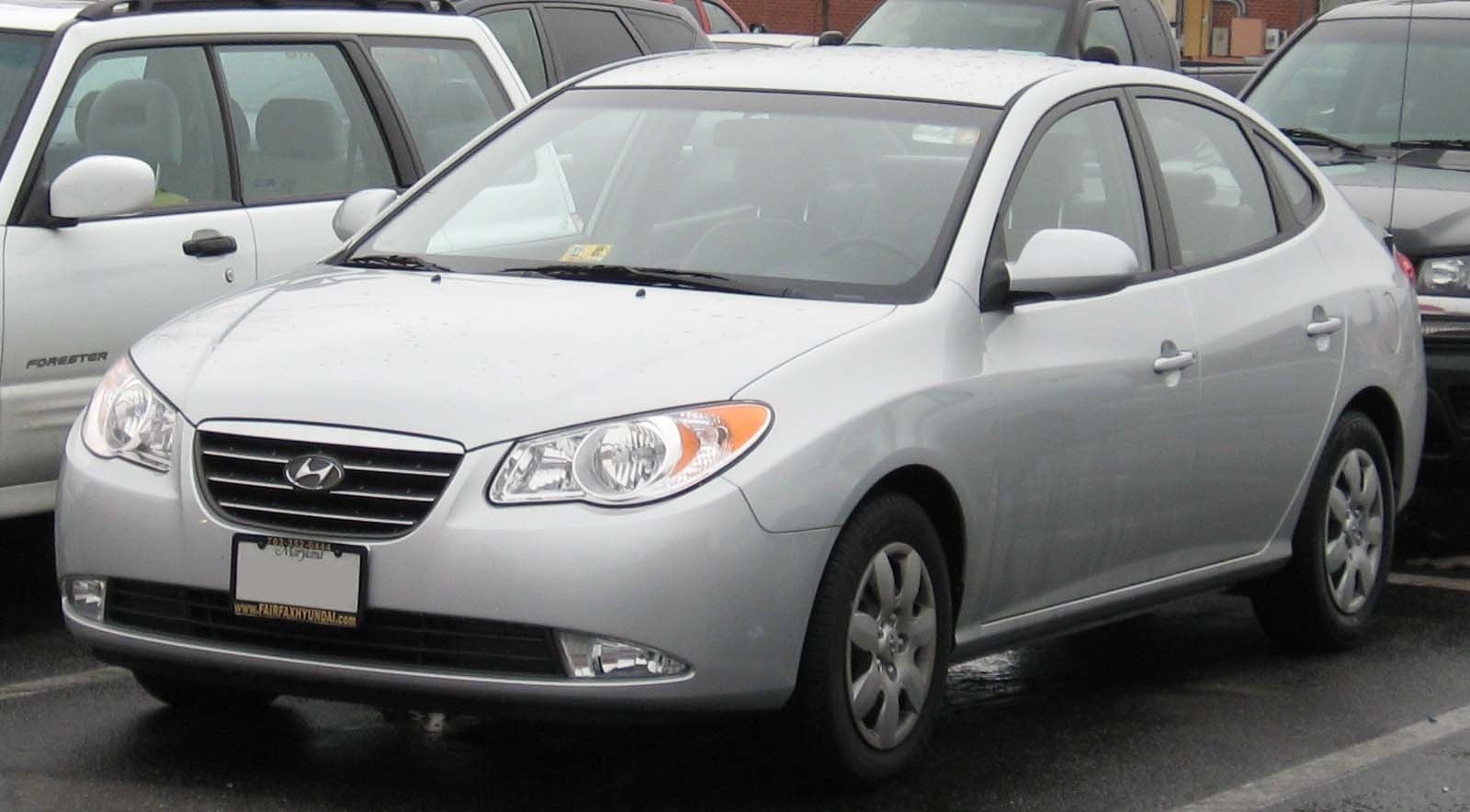 Silver sedan with prominent grille, headlights, and five-spoke wheels