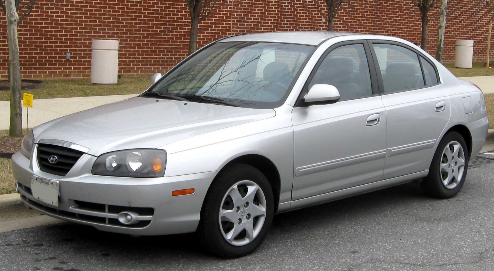 Silver sedan, rounded headlights, five-spoke alloy wheels