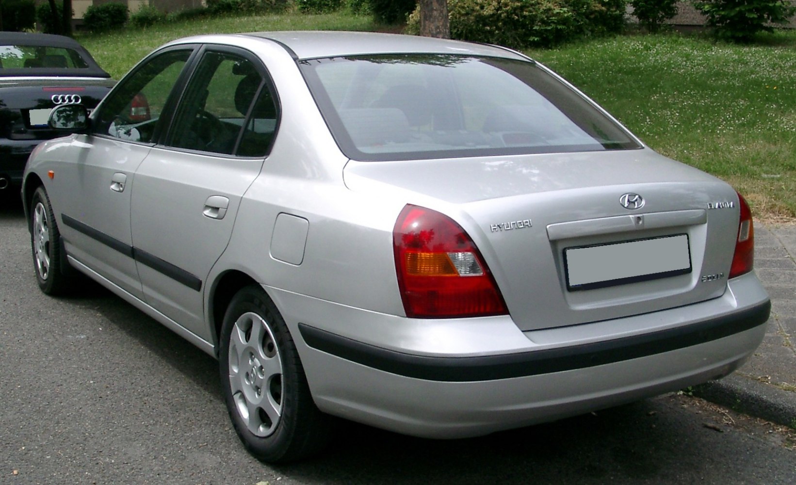 Silver sedan rear side view with distinct taillights and classic design