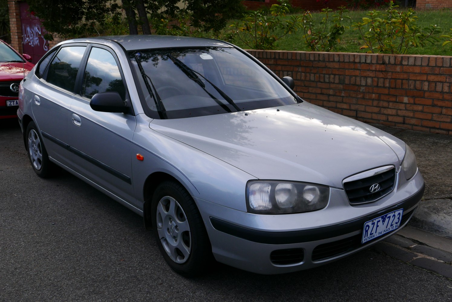 Front-side exterior of compact hatchback with distinct headlights and alloy wheels
