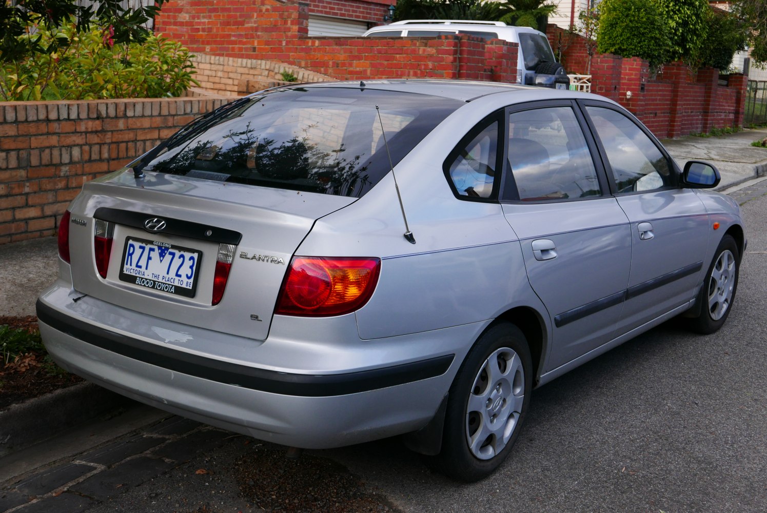 Rear side view of silver hatchback with taillights and antenna