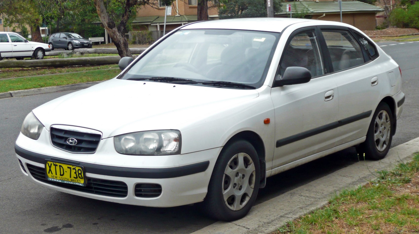 Front and side view of a white hatchback with distinct headlights and grille