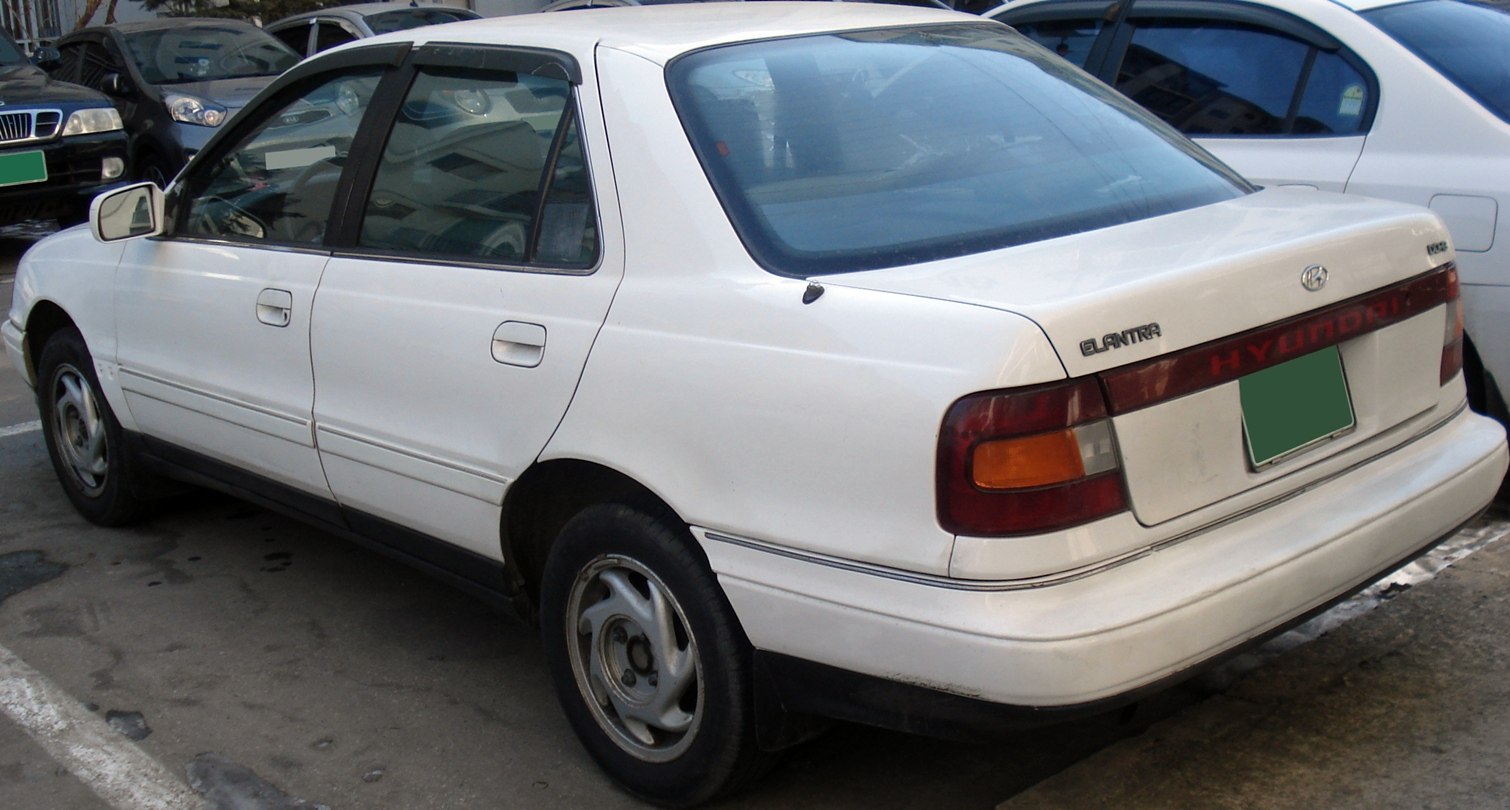 Rear and side view of a 1990s four-door sedan with distinctive tail lights