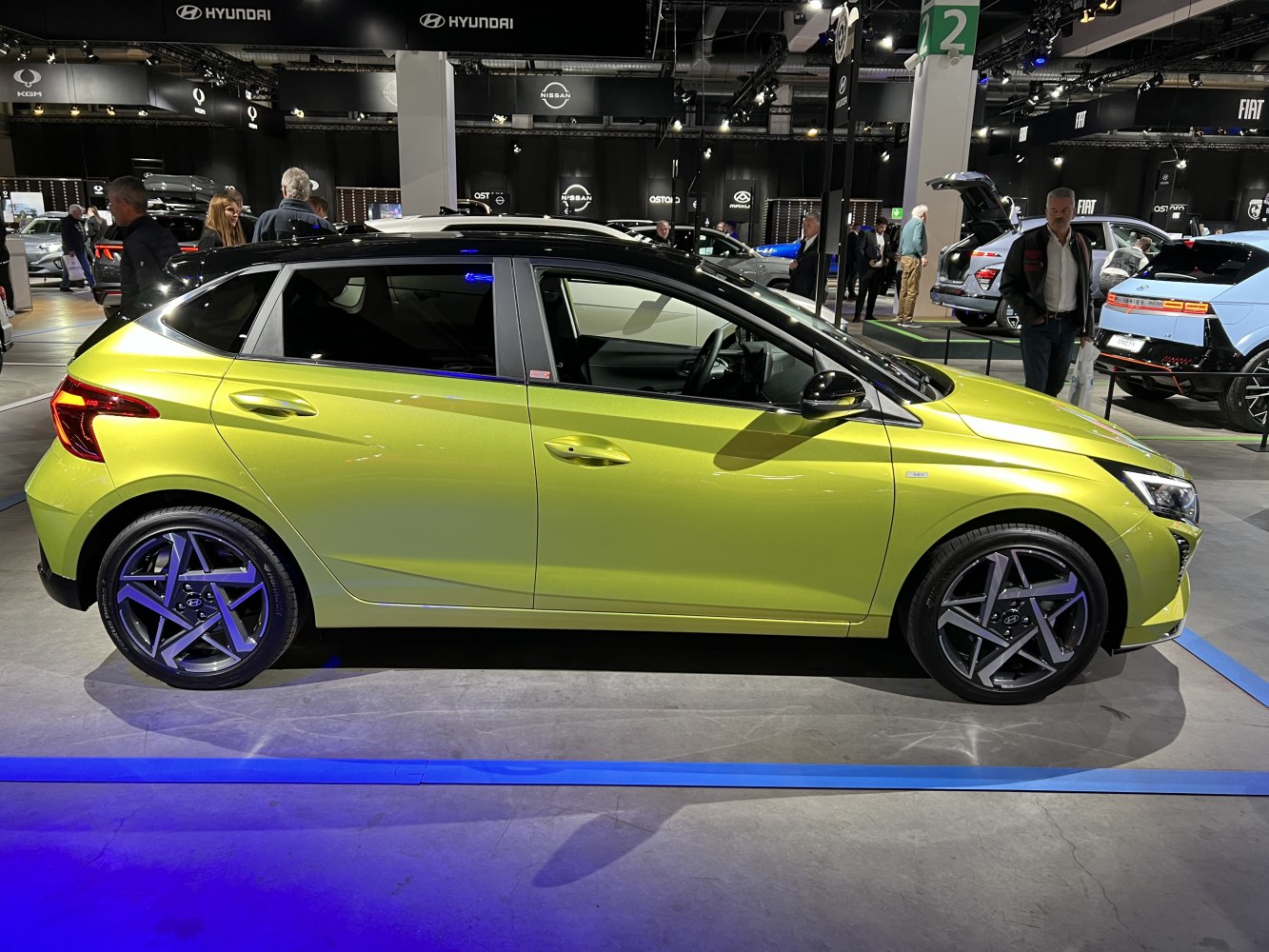 Side profile of a lime green hatchback with distinctive alloy wheels