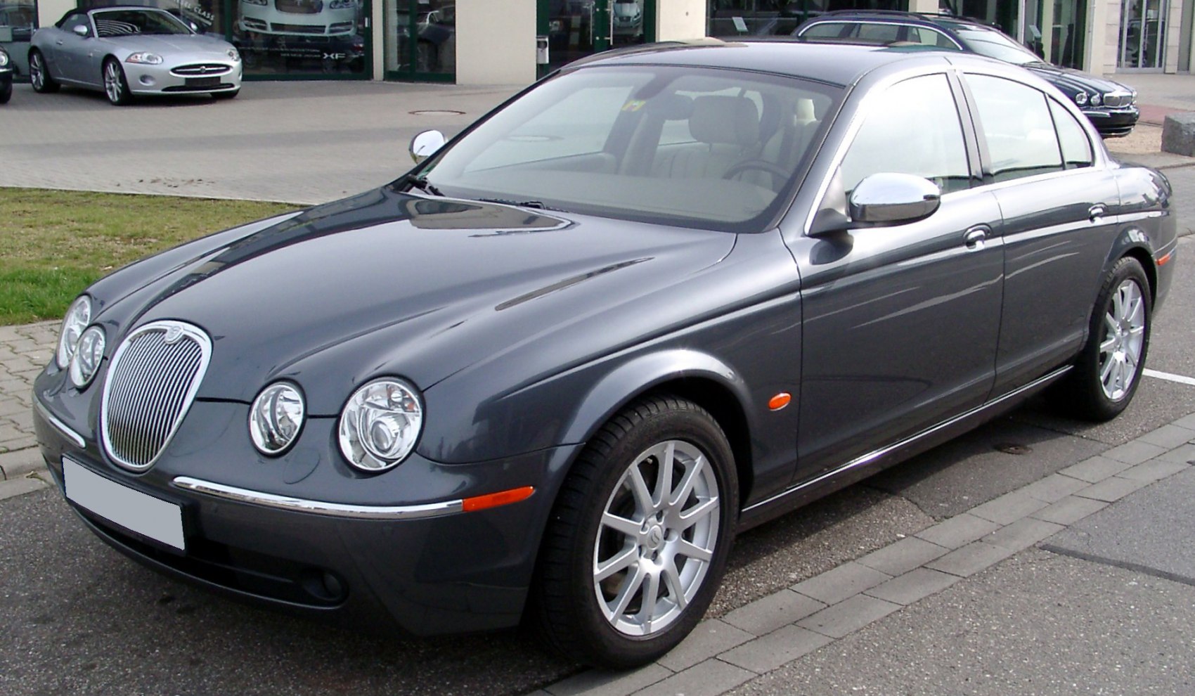 Front view of a sedan with quad headlights and prominent chrome grille