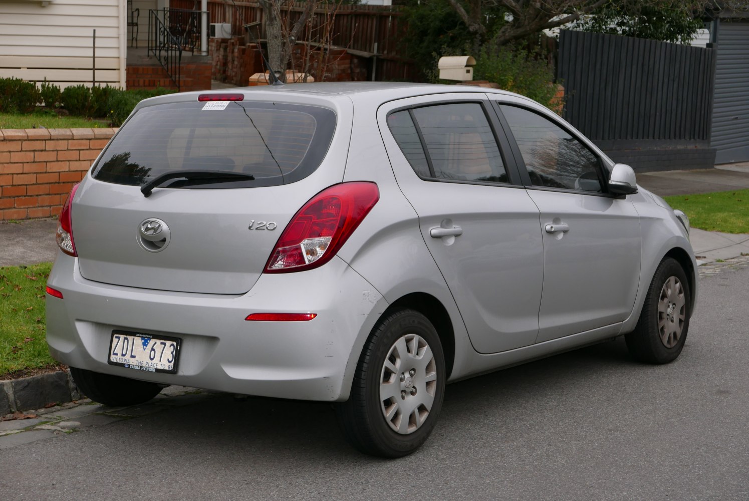 Rear side view of silver compact hatchback with prominent taillights