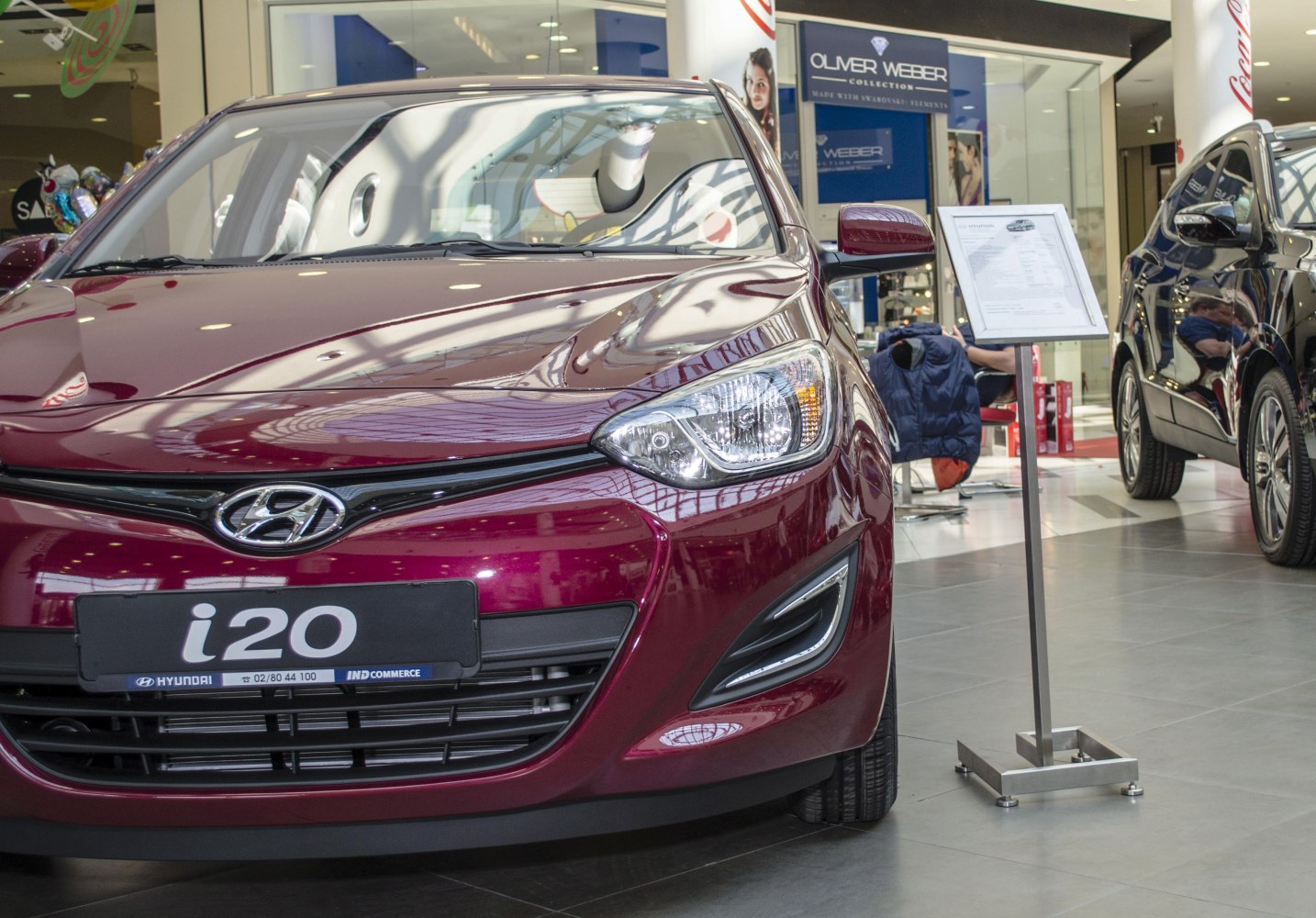 Front grille and headlight of modern compact hatchback in showroom.
