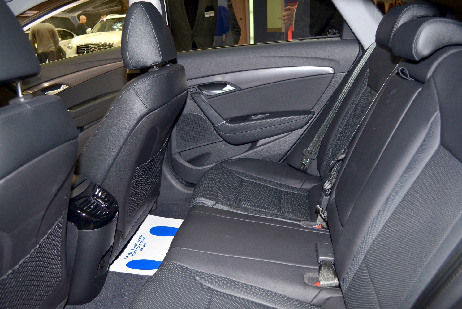 Rear seat with black upholstery, door panel, and rear ventilation controls