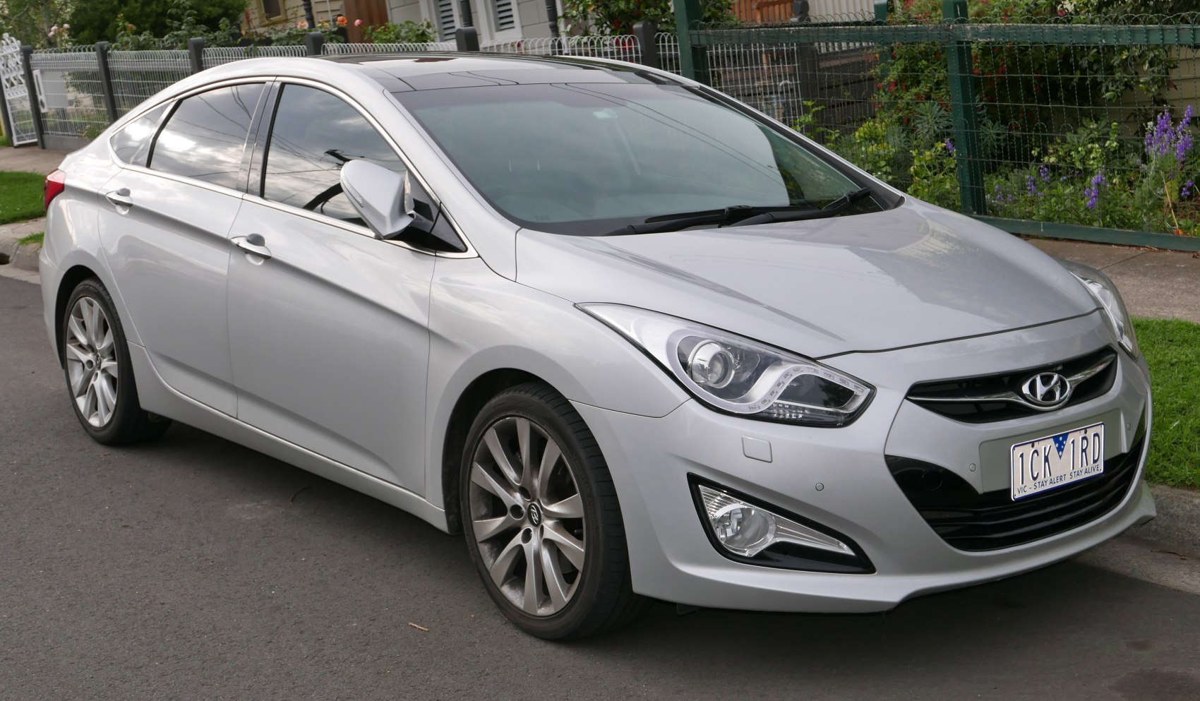 Silver sedan with sleek headlights and alloy wheels, front-side view.