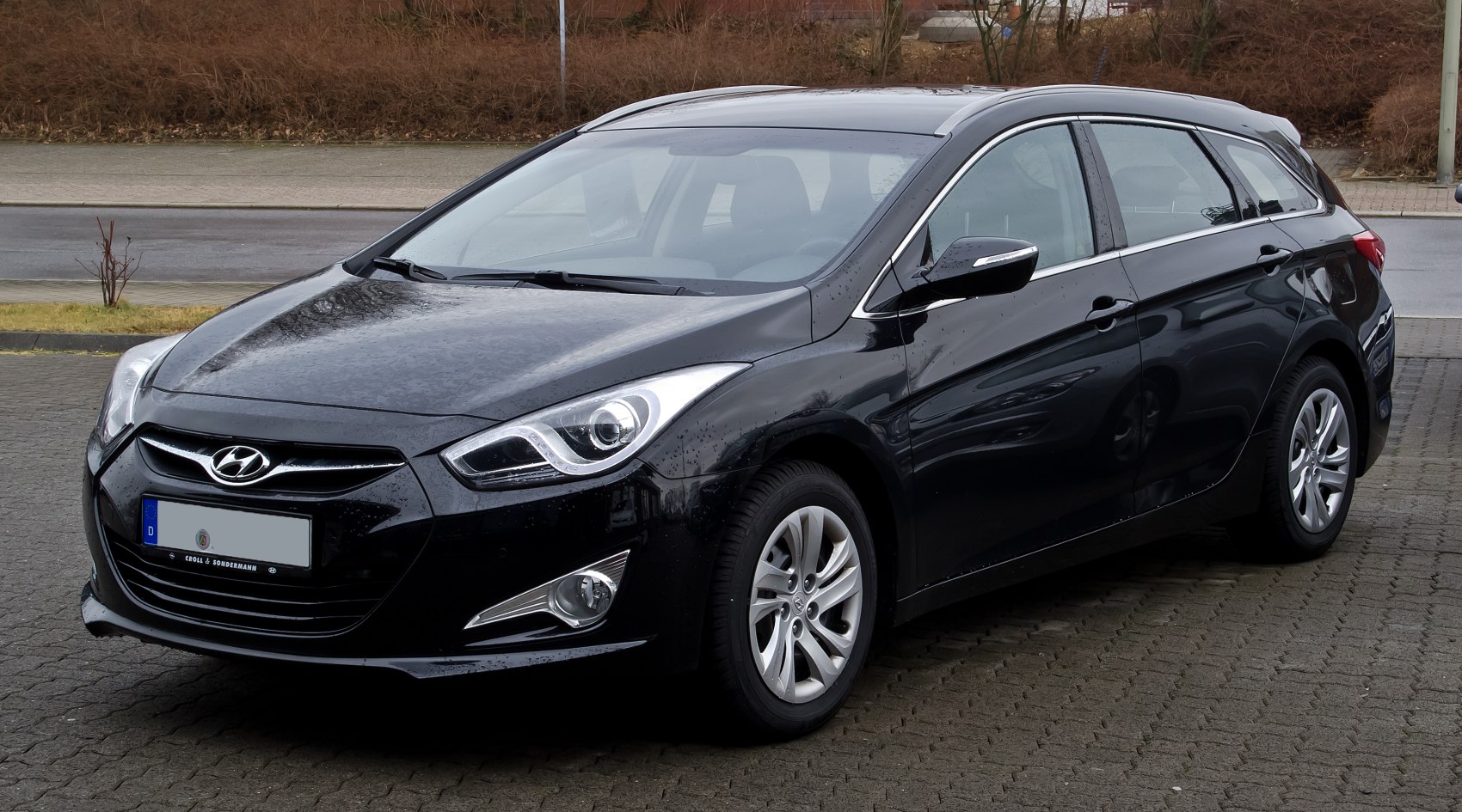 Sleek black station wagon with pronounced headlights and alloy wheels