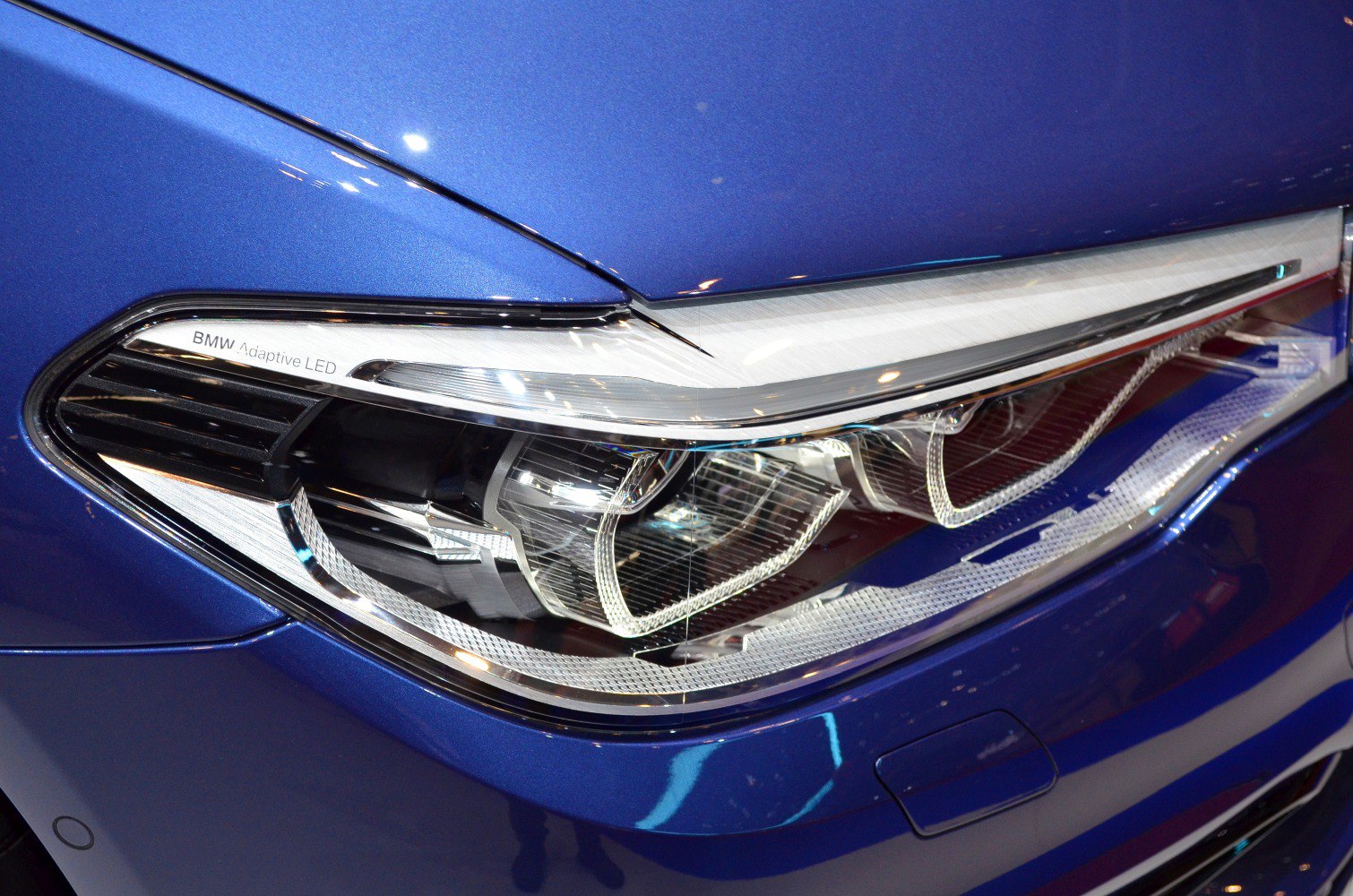 Close-up of adaptive LED headlight on blue car front