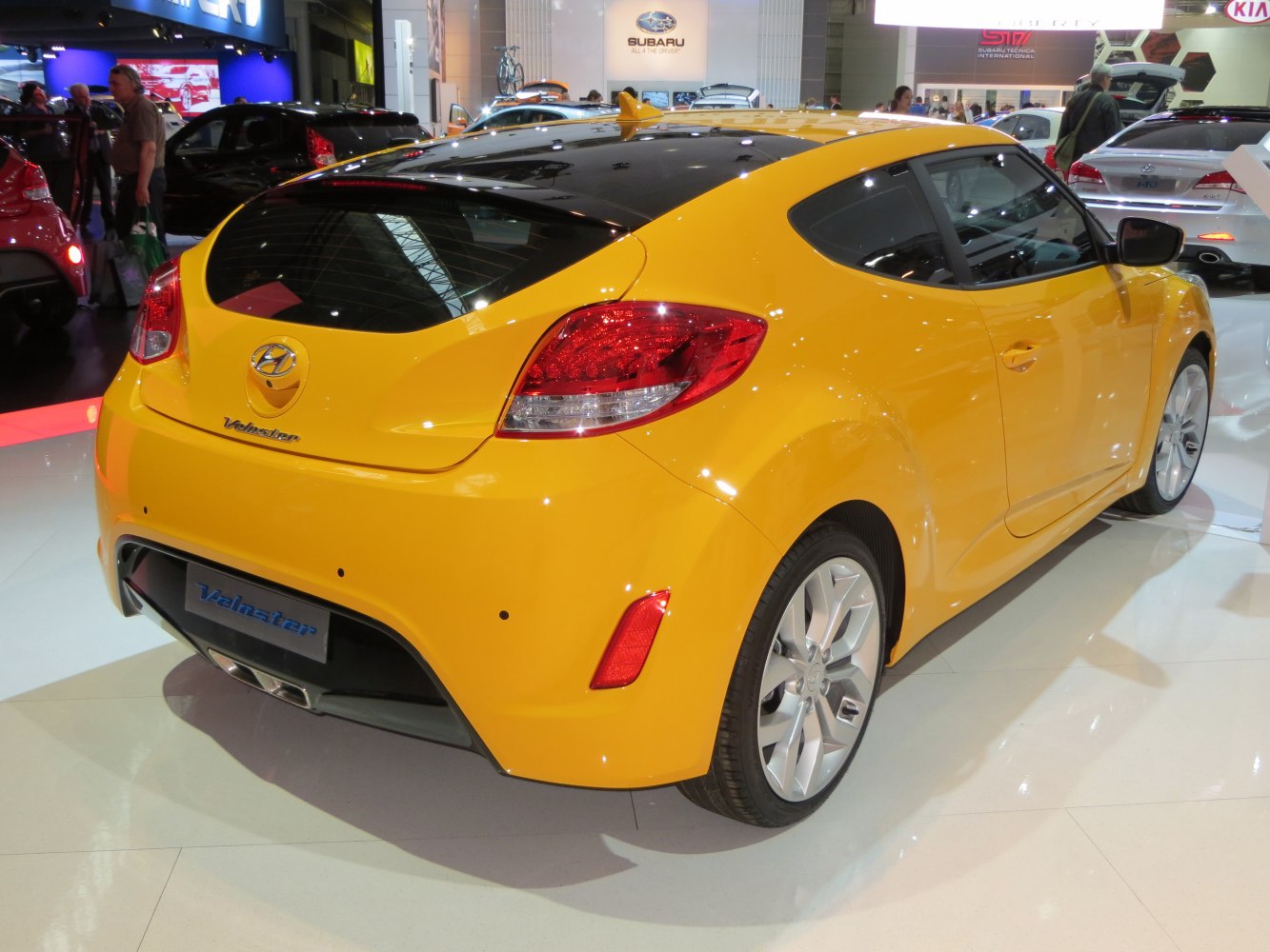 Yellow car rear view with black roof and dual exhaust