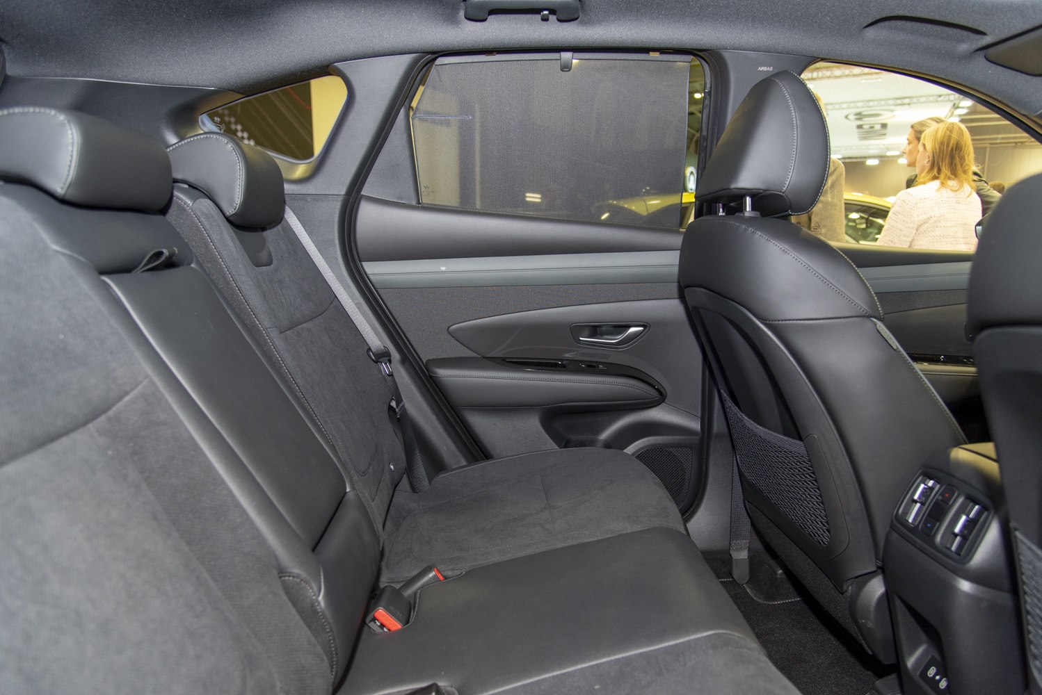 Modern rear seat interior with leather and fabric upholstery and rear door panel