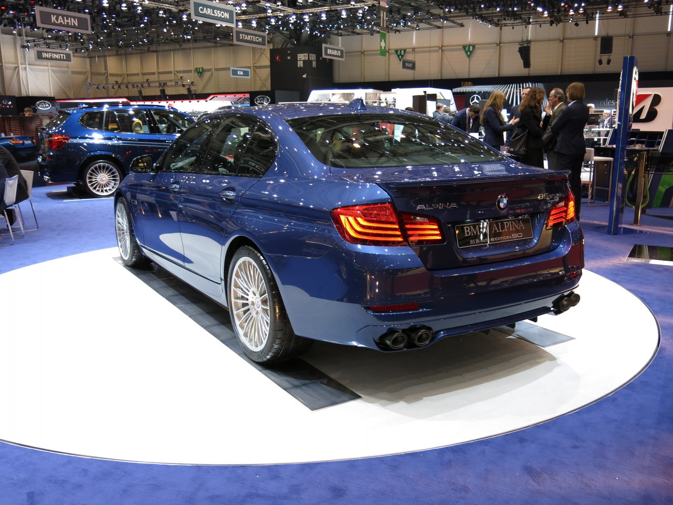 Sedan rear with quad exhausts and multi-spoke wheels