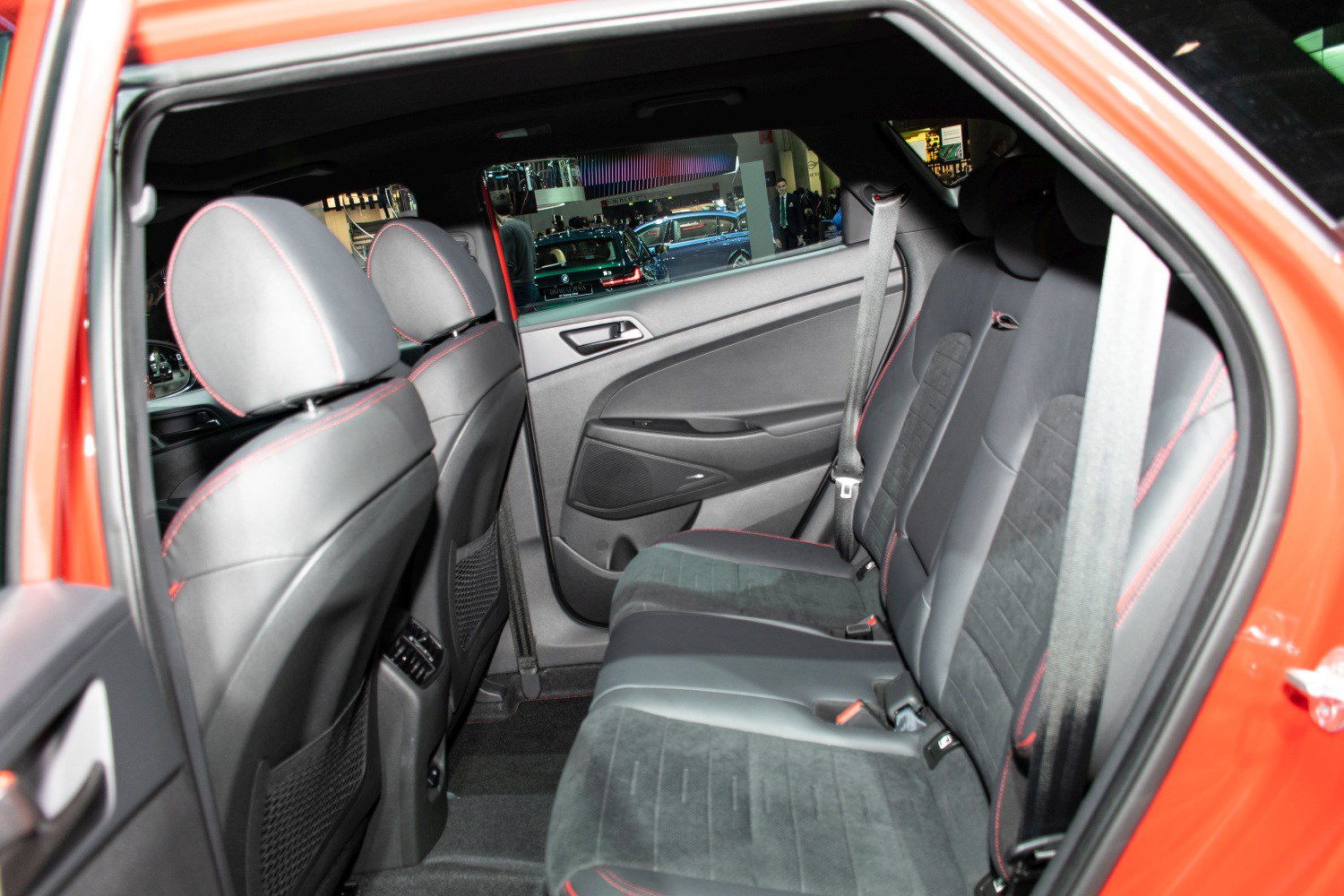 Rear seat with black upholstery and red stitching in a compact SUV