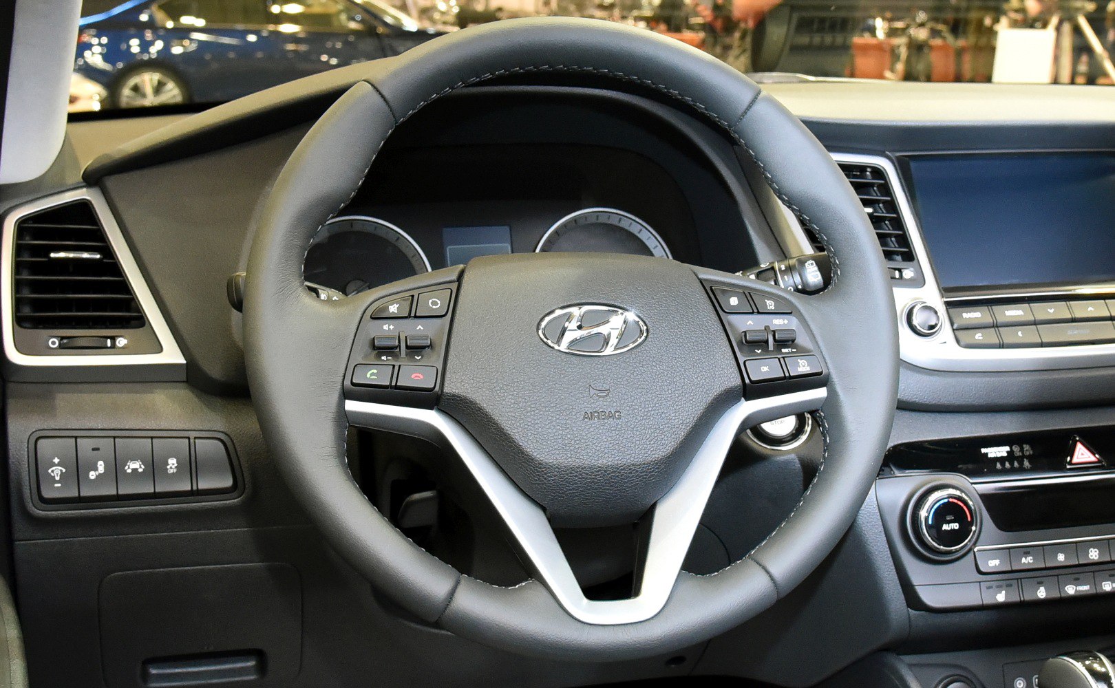 Steering wheel with controls and dashboard with touchscreen in modern car interior