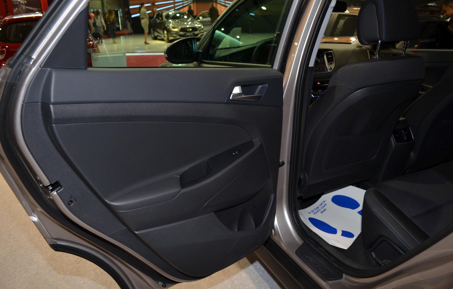 Rear door interior panel and rear passenger seating area with door handle and window switch.