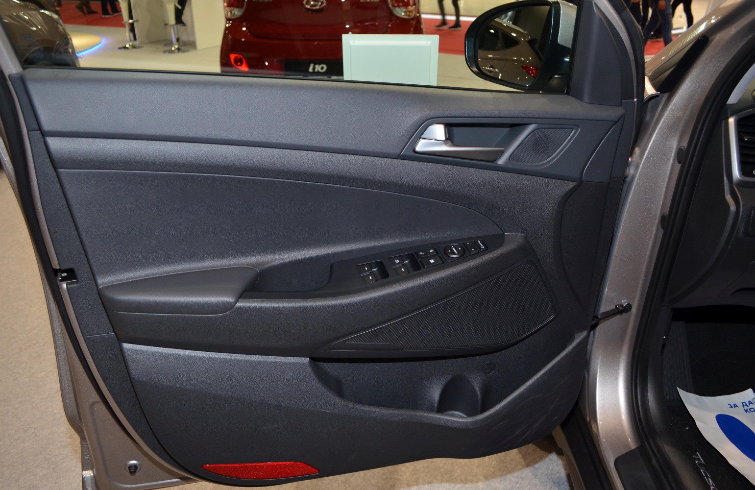 Interior door panel with window and mirror control buttons.