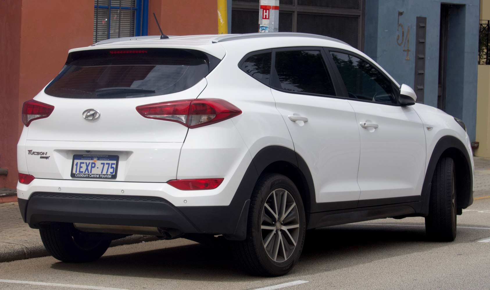 Rear side view of white SUV with distinctive taillights and black bumper trim