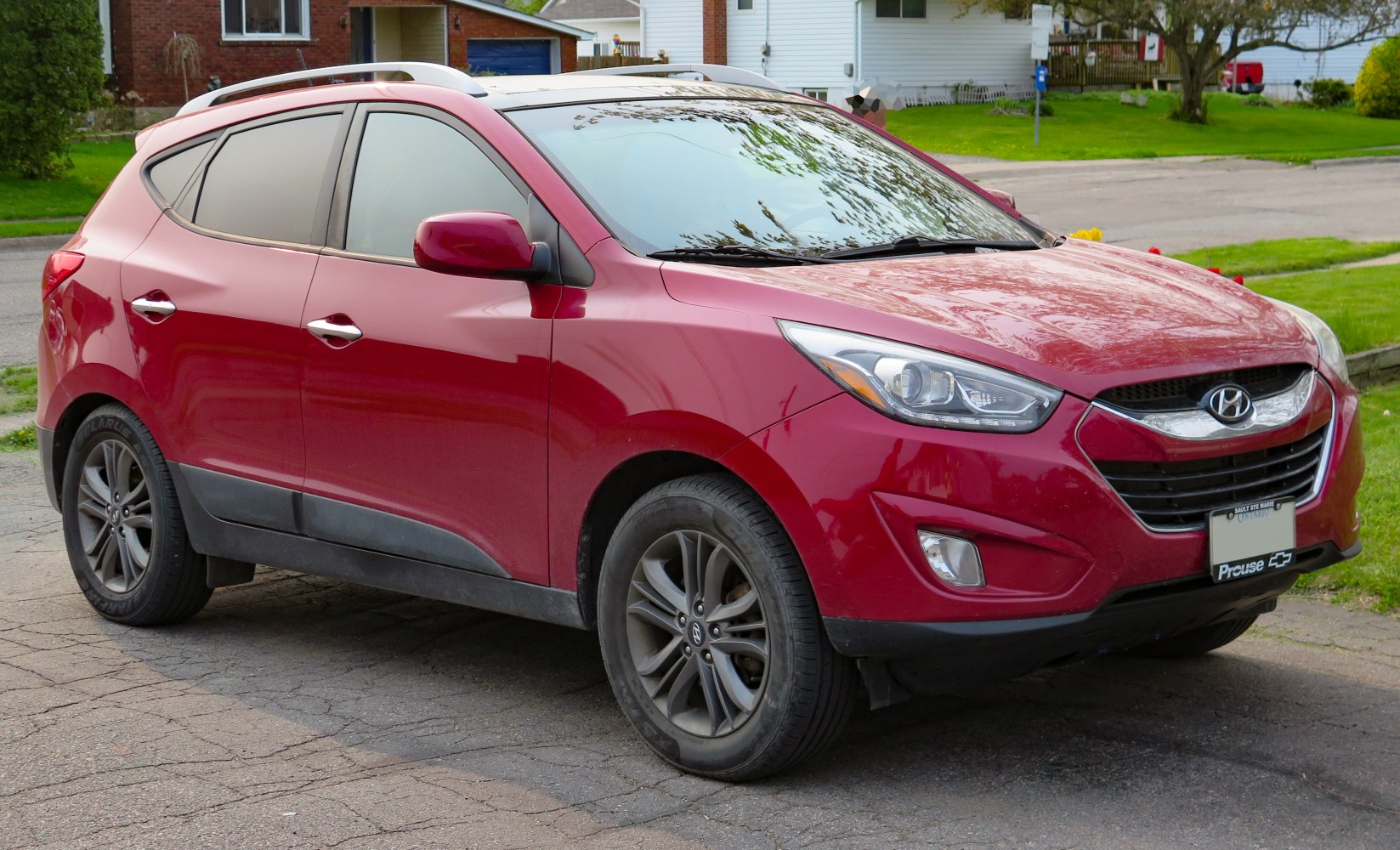 Red mid-size SUV with sleek headlights and sporty wheels