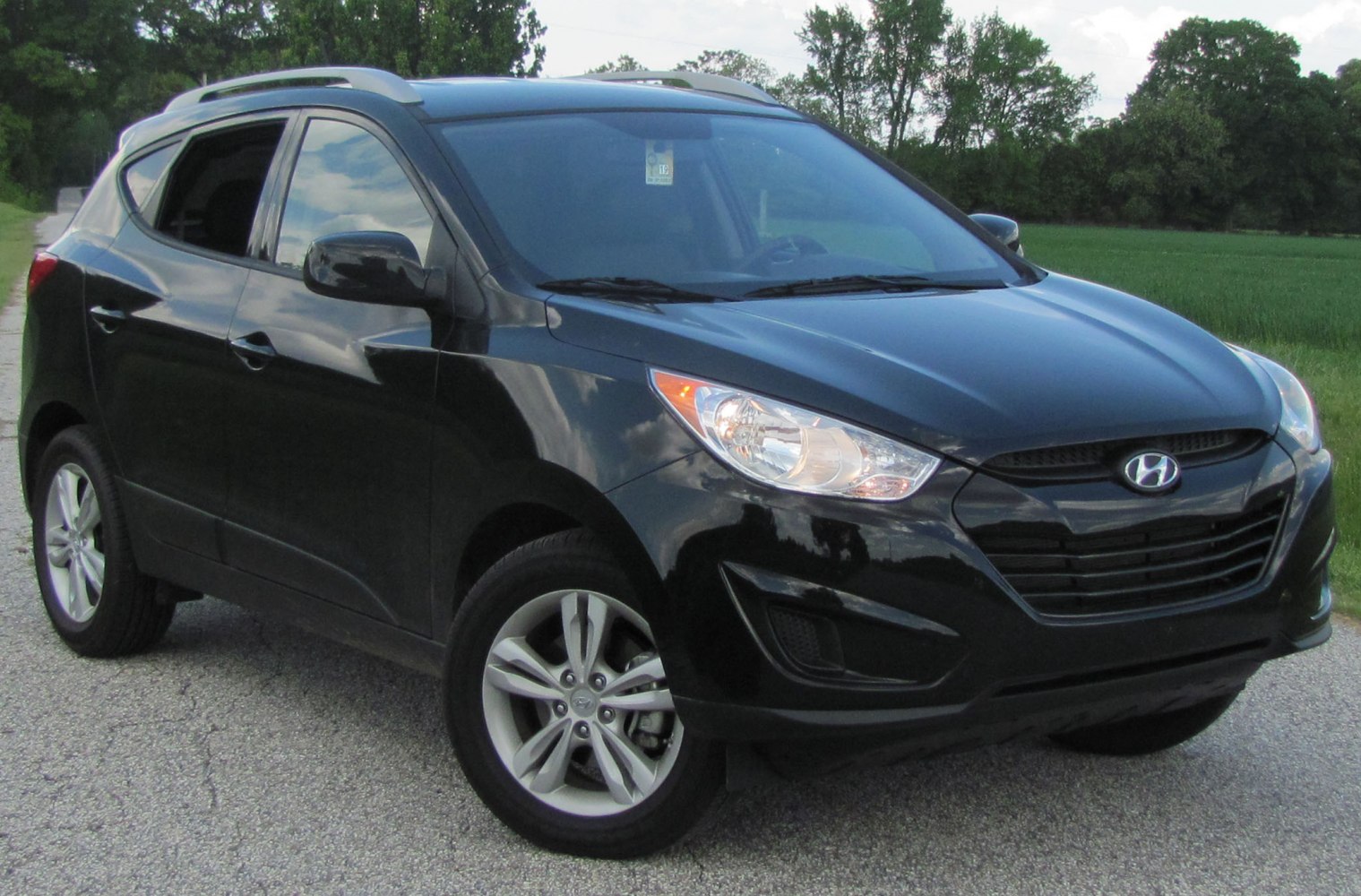 Black compact SUV showing front and side exterior with headlights and alloy wheels