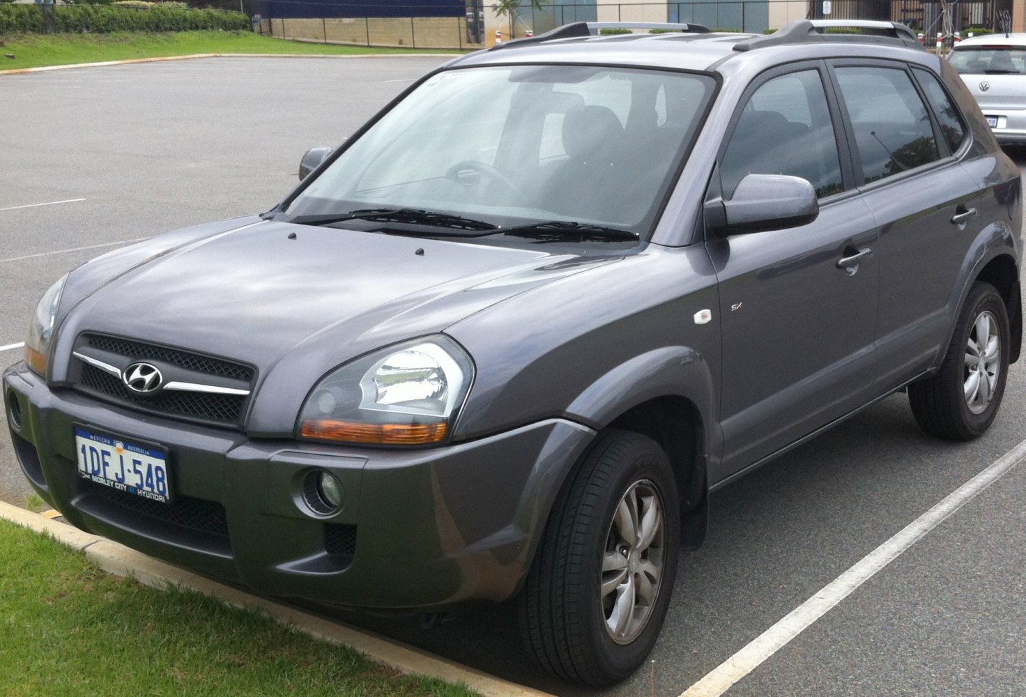 Front and side view of a mid-2000s compact SUV with roof rails and alloy wheels.