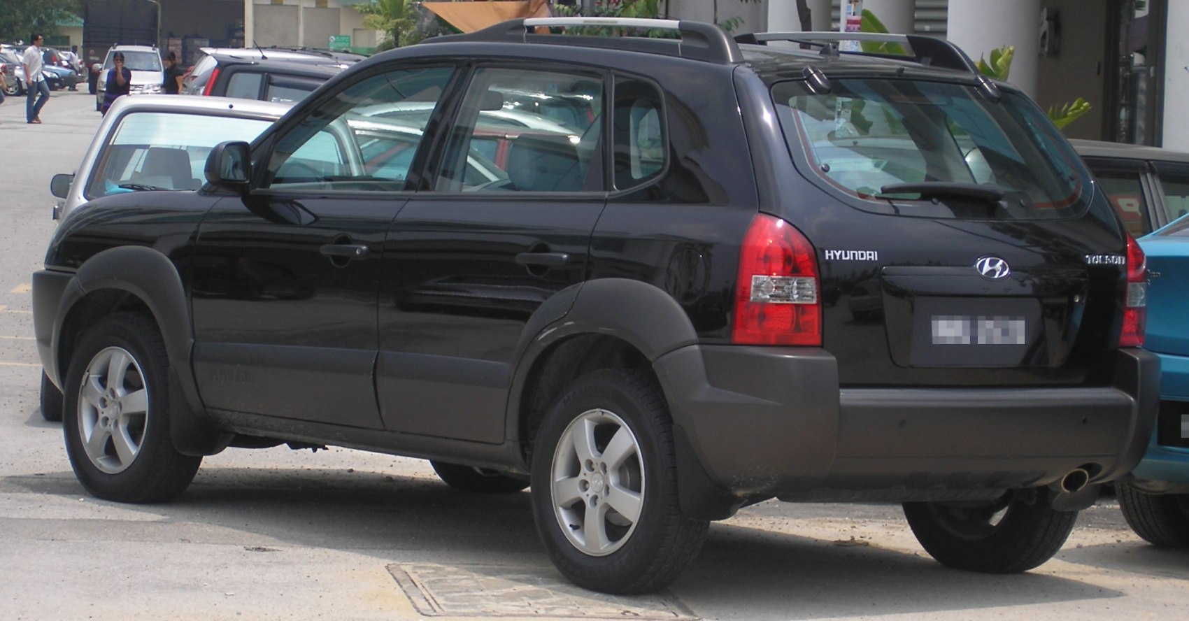 Rear side view of rugged SUV with roof rails and alloy wheels