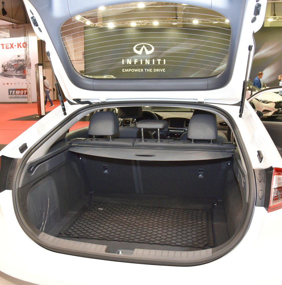 Rear cargo space with black interior and protective net in hatchback.