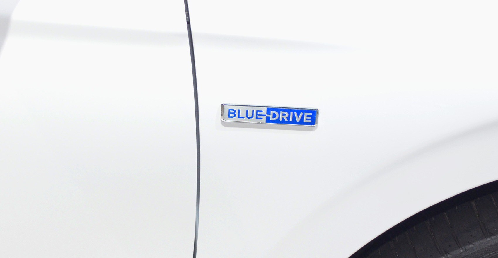 Close-up of Blue Drive hybrid emblem on white vehicle body